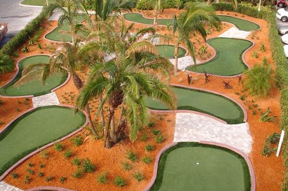 Greenwich Aerial view of a mini golf course with synthetic grass and palm trees.